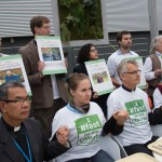 An interfaith group of religious leaders sits in front of empty trays during a public action at COP21 in Paris in 2015. Photo: Ryan Rodrick Beiler/LWF
