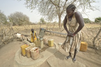 A mother and daughter draw water from a well with a hand pump in South Sudan. Photo: Paul Jeffrey/ACT