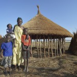 Adhieu Deng Ngewei and three of her children pose in front of their new hut on April 12, 2017, in Dong Boma, a Dinka village in South Sudan's Jonglei State. They and most other families here recently returned home after being displaced by rebel soldiers in December, 2013, and they face serious challenges in rebuilding their village while simultaneously coping with a drought which has devastated their cattle herds.
During the period they were displaced, this family took refuge on an island of the White Nile River, living on the edge of starvation for almost three years.
The Lutheran World Federation, a member of the ACT Alliance, is helping the villagers restart their lives with support for housing, livelihood, and food security. The ACT Alliance funded the construction of this family's new hut. South Sudan