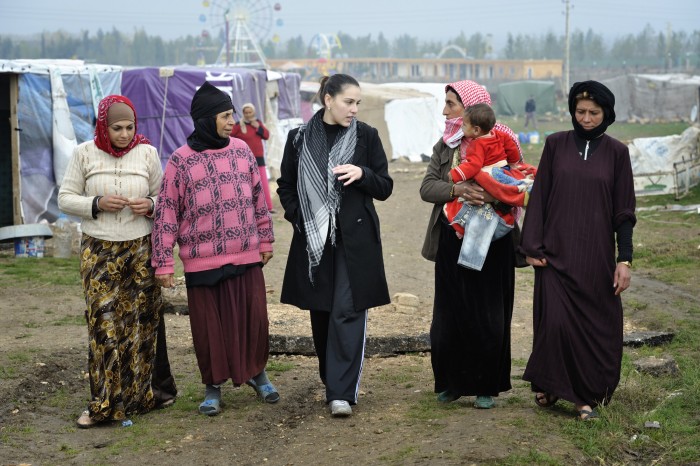 Sabeen Abdulsater (center, in black coat), project officer for the Bekaa Valley for International Orthodox Christian Charities, talks with women refugees from Syria in the village of Jeb Jennine, Lebanon. Photo: Paul Jeffrey
