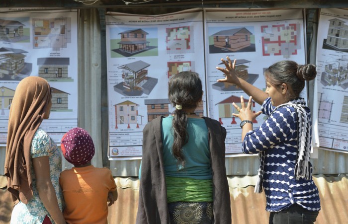 A volunteer for ACT Alliance member DanChurchAid explains to neighbours their options for constructing houses to replace the homes they lost in the 2015 Nepal earthquake. Photo Credit: ACT/Paul Jeffrey