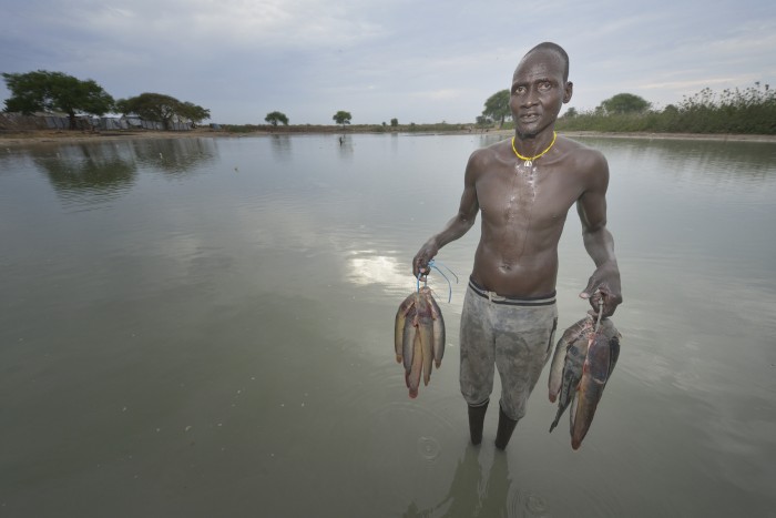 Mobil Kon displays fish he caught in Poktap, a town in South Sudan's Jonglei State where conflict, drought and inflation have caused severe food insecurity. The Lutheran World Federation, a member of the ACT Alliance, is helping families tackle food problems, including by providing cash for the purchase of fishing line and hooks. South Sudan. Photo: Paul Jeffrey/ACT