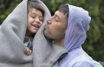 Refugees on their way to western Europe, a man from Iran holds his son as they approach the border into Croatia near the Serbian village of Berkasovo. The ACT Alliance has provided critical support for refugee and migrant families here and in other places along their journey.