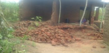 A house with fallen walls; a family is still using the remaining room