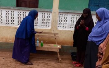 A parent teaches other parents how to use hand sanitizer after being trained by FCA. Photo: Mohamed Ibrahim/FCA Somalia